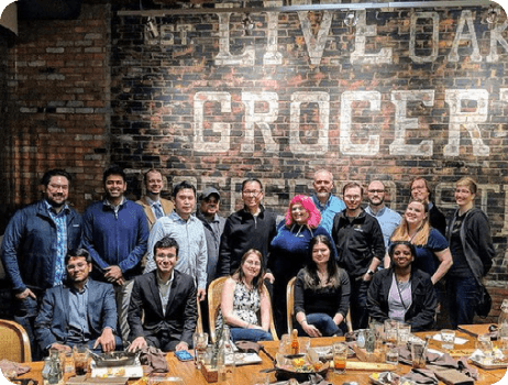 Team group photo at a long dinner table