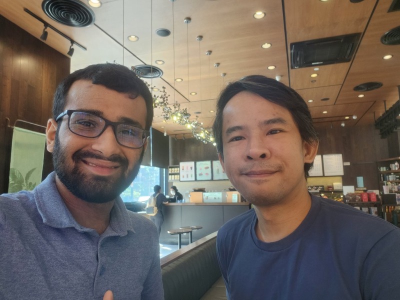 Rasikh Morani taking a selfie with a colleague in a cafe